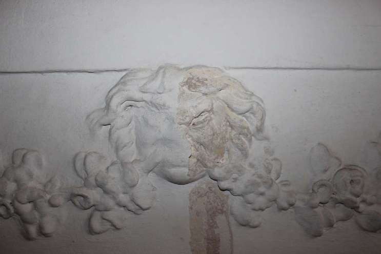 Stucco mascaron between garlands, in a room of the second piano nobile